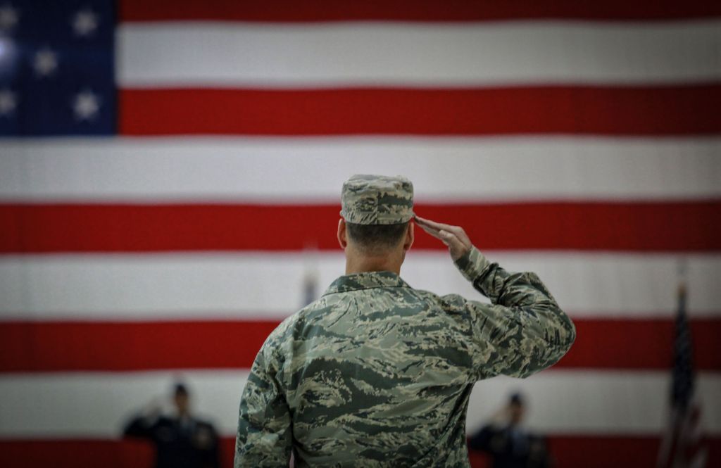 Veteran saluting American flag